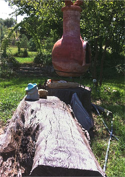 A rustic log bench and chiminea pedestal in the author’s garden.