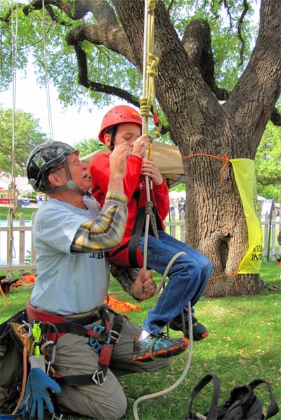 Peter Jenkins shows a young climber “the ropes” in preparation for the Fun Climb. All photos by Steve Houser.