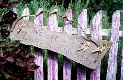 A whimsical, handcrafted sign draws inspiration from the color palette, sense of humor and recycling interests of the garden’s owner.