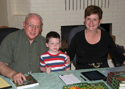 Neil at a recent book signing with wife Lynn and grandson Joseph alongside.  (Note: Joseph is unable to attend every signing due to prior commitments.)