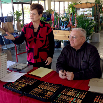 Neil and his wife Lynn visit with a customer at a book and pen sale.